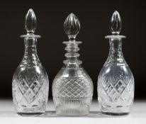 A PAIR OF CUT GLASS SHERRY DECANTERS AND STOPPERS and ANOTHER. (3).