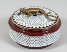 A CIRCULAR PORCELAIN BOX AND COVER with bronze lizard handle. 5.5ins diameter.