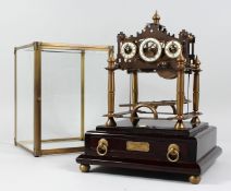 A REPRODUCTION CONGREAVE ROLLING BALL CLOCK with three dials, housed in a glass case, on a base with