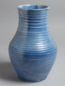 A MOORCROFT STYLE VASE, blue glazed with ribbed body. 10.5ins high.