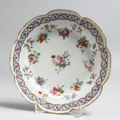 AN 18TH CENTURY BRISTOL PLATE painted with interlaced ribbons and festoons of flowers, probably by