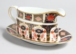 A ROYAL CROWN DERBY OLD IMARI PATTERN SAUCE BOAT AND STAND, NO. 1128.