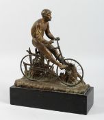 A RARE BRONZED AUTOMATRON CYCLIST riding a bicycle, on a wooden base. 10ins long , 11ins high.