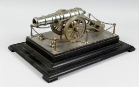 A GOOD CAST METAL MODEL OF A CANNON, on its wheeled carriage, on an ebonised plinth base. 1ft 6ins