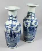 A LARGE NEAR PAIR OF CHINESE BLUE AND WHITE VASES painted with figures. 22ins & 23ins high.