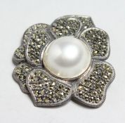 A SILVER, MARCASITE AND PEARL FLOWER HEAD BROOCH.