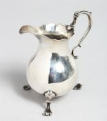 A GEORGE II PEAR SHAPED MIL JUG on three claw feet. London 1750, maker J. J.