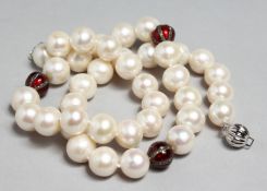 A PEARL NECKLACE INTERSPERSED WITH ENAMEL AND DIAMOND BEADS, 18ins long.