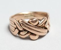 A 9CT ROSE GOLD PUZZLE RING.