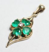 A 9CT GOLD EMERALD CLOVER PENDANT.