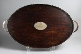 AN EDWARDIAN TWO HANDLED WOODEN AND PLATE OVAL TEA TRAY, with silver presentation tablet, 28ins