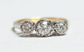 AN 18CT GOLD THREE STONE DIAMOND RING.