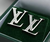 A PAIR OF SILVER L .V. STYLE INITAL EARRINGS.