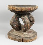 A PAPUA NEW GUINEA CARVED WOOD AND POLYCHROME DECORATOR'S STOOL, the circular top supported on