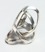 A SILVER CROSS OVER RING.