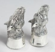 A PAIR OF 800 WHITE METAL HORSES' HEADS SALTS AND PEPPERS.