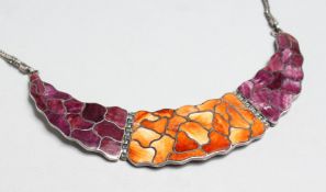 A SILVER CRESCENT SHAPE PENDANT AND CHAIN with orange and purple enamel decoration, 5ins wide.