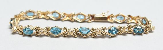 A 14CT GOLD BLUE TOPAZ AND DIAMOND BRACELET.