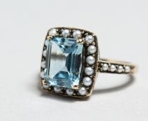 A SILVER, BLUE TOPAZ AND PEARL RING.