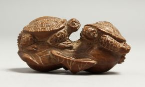 A JAPANESE CARVED WOOD NETSUKE OF TWO TURTLES Signed, 5.5cm long.