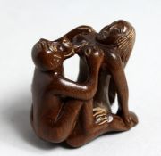 A CARVED WOOD EROTIC NETSUKE, 1.75iins high.