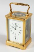 A FRENCH BRASS CARRIAGE CLOCK with eight day movement, striking on a gong enamel dial with
