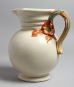 A CLARICE CLIFF JUG with floral handle. 9ins high.