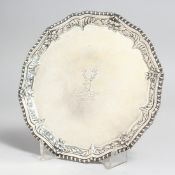 A GEORGE III SILVER CIRCULAR WAITER, 7ins diameter, with gadrooned edge, deer's head crest.