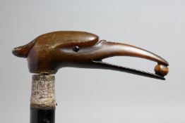 A WALKING CANE WITH CAVED RHINO, BIRD HANDLE.