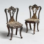 A PAIR OF SILVER MINIATURE SILVER CHAIRS, 2ins long.