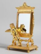 A GOOD SMALL GILT BRONZE TABLE MIRROR with cherubs mount. 9ins high.
