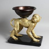 AN UNUSUAL GILT BRONZE AND PATTINATED BRONZE CENTREPIECE modelled as a monkey on all fours, a bow on