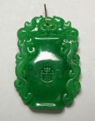 A CHINESE CARVED JADE URN-SHAPED PENDANT with gold rim, 5cm.
