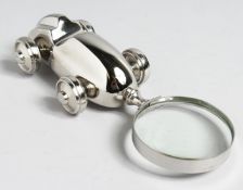 A MAGNIFYING GLASS with RACING CAR handle.