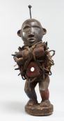 AN AFRICAN CARVED WOOD FIGURE with tubes and nails. 12ins high.