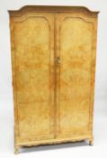 HARRODS LTD. A BLONDE WOOD TWO DOOR WARDROBE with shaped cornice, fitted interior on cabriole