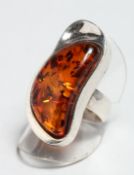 A SILVER AND AMBER RING.