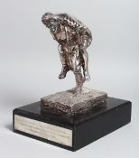 A WHITE METAL GROUP OF A SOLDIER carrying a soldier on his back. 7.5ins high, on a rectangular base,
