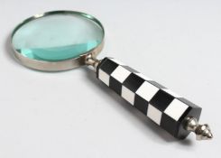 A MAGNIFYING GLASS with CHEQUERED handle.