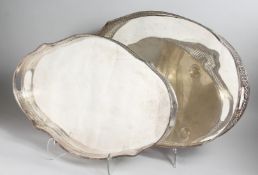 A SILVER PLATED OVAL TEA TRAY with pierced border and carrying handles, 24ins long and ANOTHER