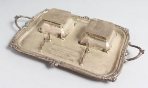 A SILVER TWO HANDLED RECTANGULAR INK STAND with two inkwells with lids on four bun feet, 15ins