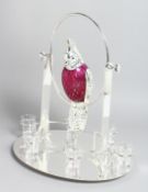A NOVELTY PLATED AND CRANBERRY COLOURED GLASS DRINKS SET,the decanter modelled as a parrot on a