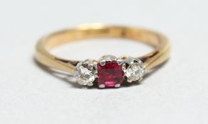 AN 18CT GOLD, RUBY AND DIAMOND THREE STONE RING.