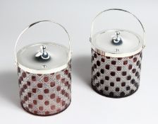 A PAIR OF CUT GLASS AND RUBY TINTED BISCUIT BARRELS with plated mounts, 6ins high.