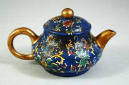 A CHINESE BLUE GROUND FAMILLE ROSE YIXING TEAPOT, the base with impressed four character mark, 11.