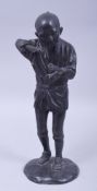 A JAPANESE MEIJI BRONZE FIGURE OF A FARMER HOLDING A PIPE, on a circular bronze base, 29.5cm high.