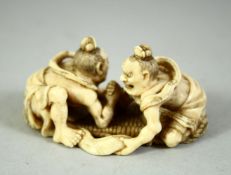 A SMALL JAPANESE CARVED IVORY OKIMONO, depicting two male figures arm wrestling, signed to base, 5.