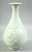 A CHINESE CELADON GLAZE DRAGON VASE, the body with carved dragon and stylised clouds, 30cm high.