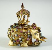 AN INDIAN CARVED IVORY ELEPHANT FIGURE, caparisoned with gilt metalwork inset with a variety of