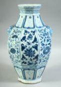 A CHINESE BLUE AND WHITE OCTAGONAL SHAPE VASE, painted with floral panels and with two moulded beast